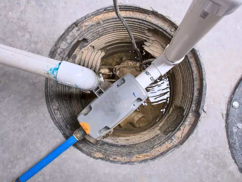 plumber fixing white sink pipe with adjustable wrench sump pump installation repair